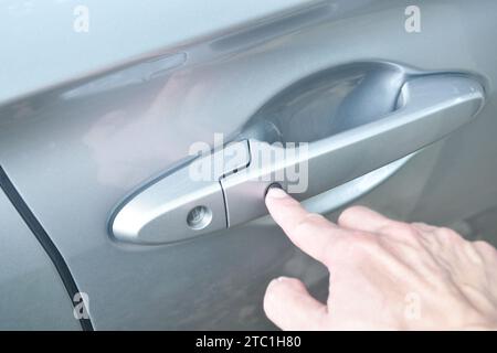 car door opened by finger pushing button and pulling Stock Photo