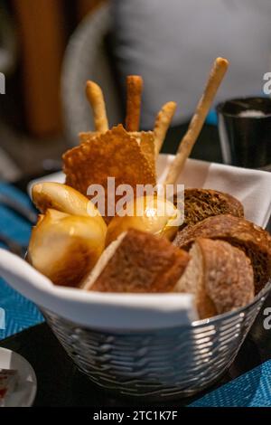Different types of sliced bread in the basket, on the table in the restaurant Stock Photo