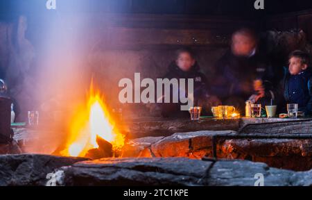 Saariselka, Finland - November 29, 2010. Family in a Sami 'kota'. The kota (also goahti), is a Sami hut or tent. It has a fireplace in the center and Stock Photo