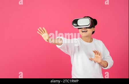 Excited asian woman using VR glasses, touching something invisible at copy space Stock Photo