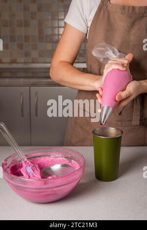 Transfer macaroon batter into piping bag fitted with round tip. using of pastry bag for french pastry macaroon, woman cooking at home Stock Photo