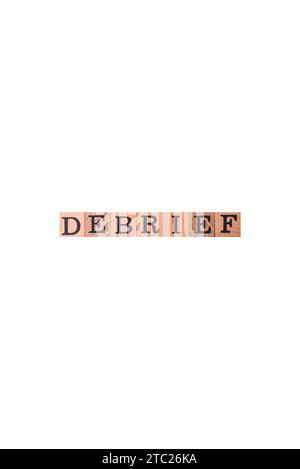 The inscription debrief in wooden cubes on a dark concrete background. Can be used as part of your composition Stock Photo