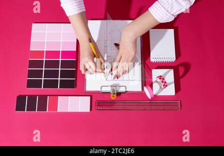 A professional designer who designs with backgrounds and props in Viva Magenta color Stock Photo