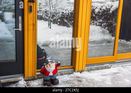 Charming sight of Santa Claus standing in front of entrance door to villa on frosty winter day. Sweden. Stock Photo