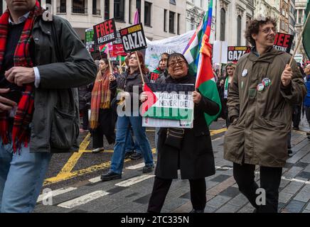 London / UK - Dec 9 2023: As Asian pro-Palestinian female protester holds banner reading 'Palestine Will Never Die' at a demonstration calling for an Stock Photo