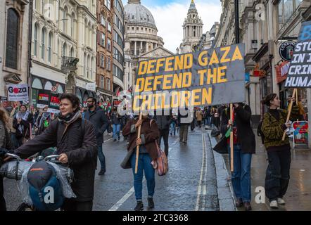 London / UK - Dec 9 2023: Pro-Palestinian protesters holds banner reading 'Defend Gaza, Defend the Children' outside St Pauls Cathedral at a demonstra Stock Photo