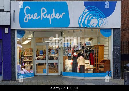 Sue Ryder brand sign above non profit charity shop front window & interior display sells used second-hand merchandize cash provides palliative help UK Stock Photo