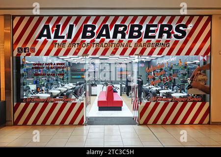 Ali Barbers 'just opened' early morning view into shop front windows new fully equipped barber business premises indoor shopping mail Essex England UK Stock Photo