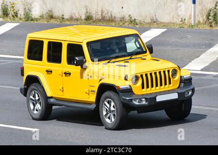 JEEP Wrangler Sahara 4x4 wheel drive roof side front view bright yellow moving & driving along London orbital route on M25 motorway Essex England UK Stock Photo