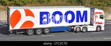 Haulage transport business white hgv lorry truck rig & semi trailer red oversized logo & attention grabbing blue BOOM advert driving on M25motorway UK Stock Photo
