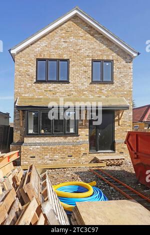 Series of 40+ stages of work on detached house canopy complete interior trades generating rubbish for skip yellow gas blue water connection England UK Stock Photo