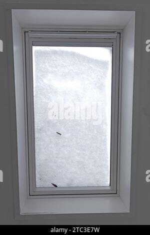 View through the roof window covered by melted snow from inside the building, selective focus Stock Photo