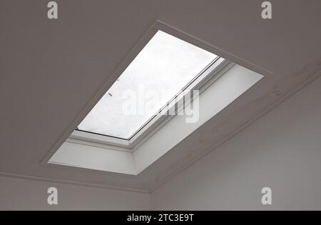 View through the roof window covered by melted snow from inside the building, selective focus Stock Photo