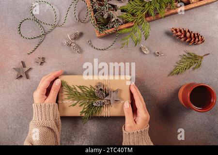 Christmas decor and Womans hands decorating handmade gift box Stock Photo