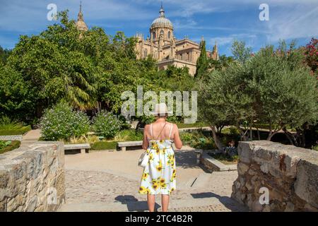 Woman in the Huerto de Calixto y Melibea gardens with a view of the Cathedral in the Spanish city of Salamanca Spain Stock Photo
