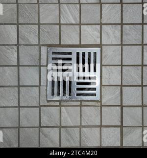 Shower stall floor drain stainless steel with tiled ground Stock Photo
