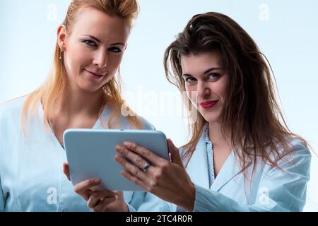 Professional exchange between two doctors reviewing medical information on a portable screen Stock Photo