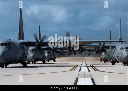 Three U.S. Air Force (USAF) C-130J Super Hercules assigned to the 36th Expeditionary Airlift Squadron, a Royal Canadian Air Force (RCAF) 436th Transport Squadron C-130J Super Hercules, a Japan Air Self-Defense Force (JASDF) C-130H Hercules assigned to the 401st Tactical Airlift Squadron, and a Republic of Korea Air Force (ROKAF) C-130H Hercules assigned to the 251st Airlift Squadron sit on the runway in support of an Operation Christmas Drop 2023 (OCD 23) elephant walk at Andersen Air Force Base, Guam, Dec. 9, 2023. Throughout OCD 23, USAF, RCAF, JASDF, and ROKAF crewmembers delivered 210 bund Stock Photo