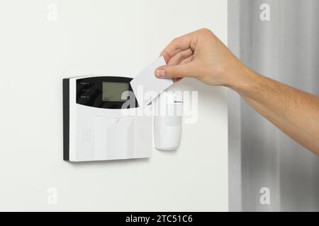 Home security system. Man using key card indoors, closeup Stock Photo