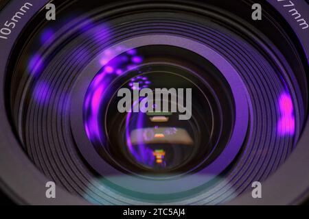 Violet reflections in the glass of a photographic lens. Macro photography in dark tones Stock Photo