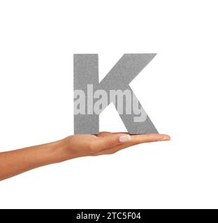 Hand of woman, capital letter K and presentation of consonant isolated on white background. Character, font and palm with English alphabet typeface Stock Photo