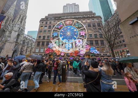 New York City, United States. 10th Dec, 2023. People are taking photos with mobile devices outside, across the street from Saks Fifth Avenue in New York, New York, on December 10, 2023. (Photo by Gordon Donovan/NurPhoto) Credit: NurPhoto SRL/Alamy Live News Stock Photo