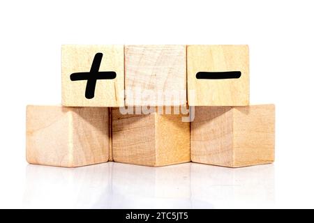 business concept.. Plus, minus symbols inscription on wooden cubes on a white background Stock Photo