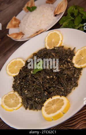 Lebanese recipe Mouloukhia , Melokhiyah, corete leaf, coriander, rice, chicken, grilled pita Stock Photo