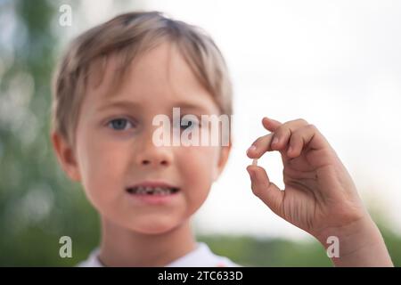 6 years old boy shows the ruptured milk tooth Stock Photo