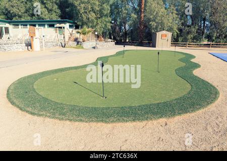 Golf hole in putting green. The putting green is a mini golf course to practice the putter golf shot. Stock Photo