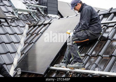 Technician Using a Multimeter for Solar Panel Installation Stock Photo