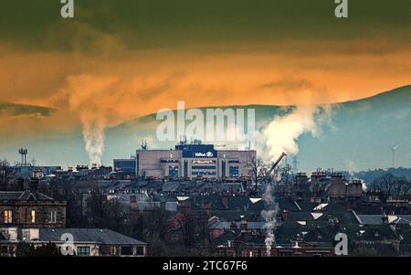 Glasgow, Scotland, UK. 11th December, 2023. UK Weather:  Cloudy Dawn saw a miserable wet windy day over the west of the city. As the city centre Hilton gets a backdrop of water vapour from the distillary in rthe gorbals and a foreground of west end tennements. Credit Gerard Ferry/Alamy Live News Stock Photo