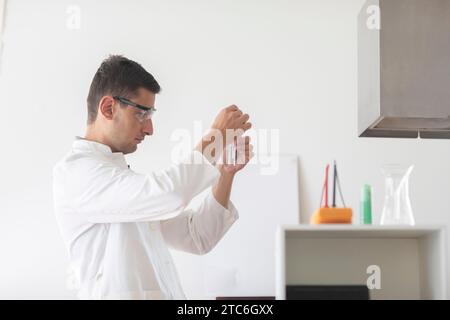 scientist male with lab glasses and gloves working in a laboratory Stock Photo