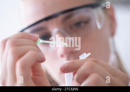 young scientist female with  lab glasses dropping with pipette Stock Photo