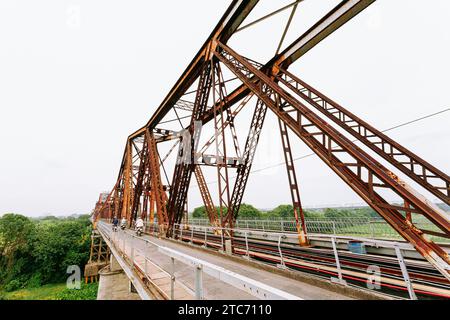 (231211) -- BEIJING, Dec. 11, 2023 (Xinhua) -- This photo taken on June 22, 2023 shows a view of Long Bien Bridge, a historic cantilever bridge across the Red River, in Hanoi, capital of Vietnam.  The Vietnamese capital city of Hanoi, located on the Red River Delta, is an ancient city with a history of more than a thousand years. With natural scenery and subtropical city view, it draws lots of visitors from home and abroad. (Photo by Pham Dinh Duc/Xinhua) Stock Photo