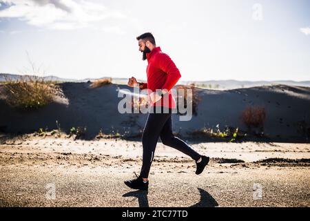 Adult man is jogging outdoor on sunny day. Stock Photo