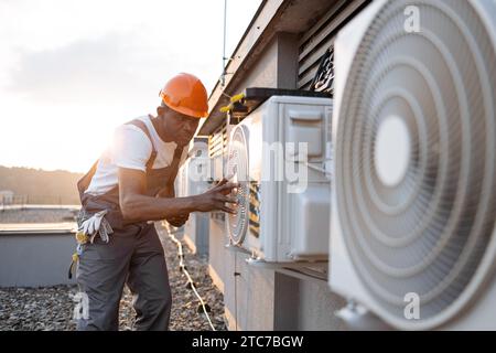 Male holding tablet and installing cooling system outdoors Stock Photo