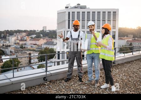 Team looking at small model of residential building outdoors Stock Photo
