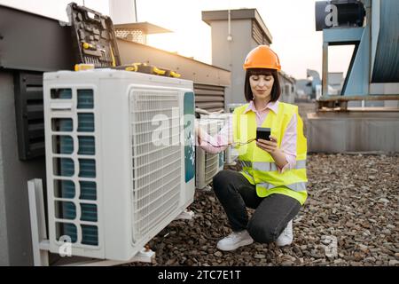 Woman using checking tool for work with air conditioner Stock Photo
