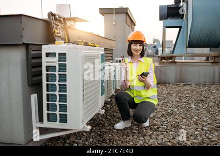 Female measuring voltage with multimeter in air conditioner Stock Photo