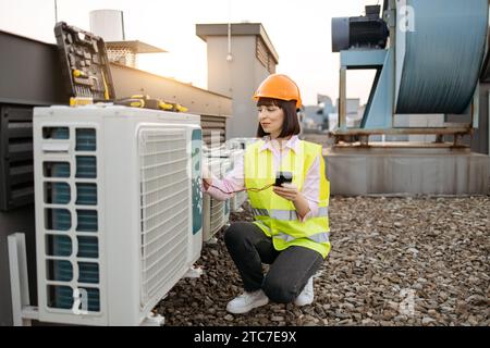 Woman using checking tool for work with air conditioner Stock Photo