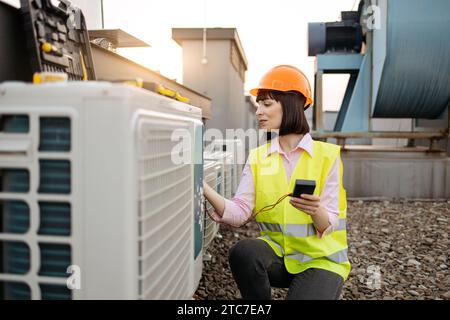 Woman using checking tool for work with air conditioner Stock Photo