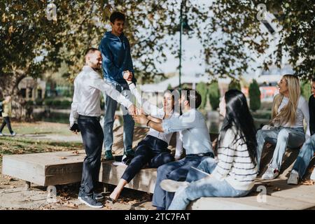 Diverse learners collaborate on a university project in a park, fostering effective learning and teamwork. Stock Photo