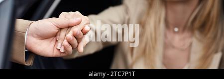 cropped view of man holding hand of elegant woman in formal wear getting out car,  banner Stock Photo