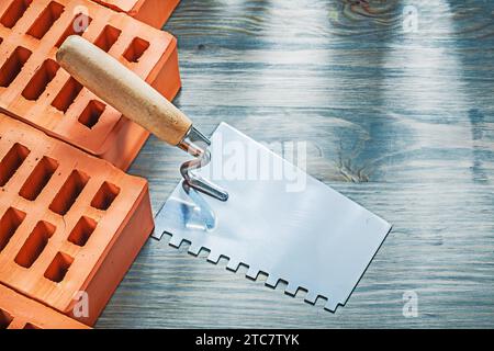 Orange bricks paint scraper on wooden board bricklaying concept Stock Photo