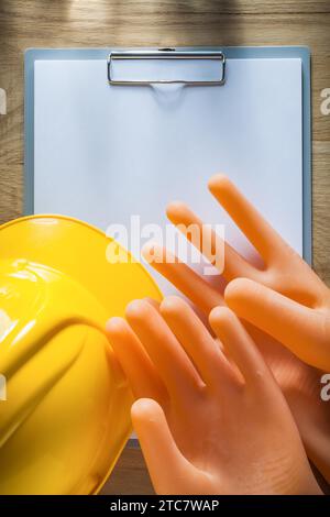 Clipboard paper dielectric gloves safety cap on wooden board Stock Photo