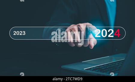Businessman touch on virtual bar status to change to 2024, countdown of merry Christmas and happy new year by technology concept, start new business a Stock Photo