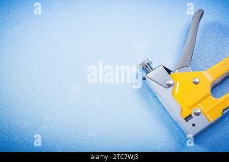 Metal staple gun on blue background construction concept Stock Photo