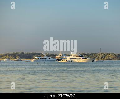 Several luxury white boats on water with reflections standing on pear ...