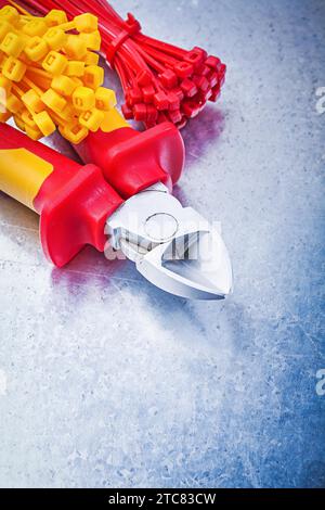 Wire cutter self-locking tying cables on scratched metallic background Stock Photo